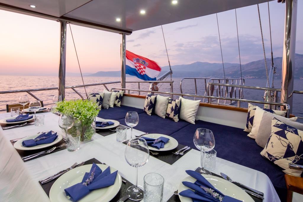 luxury yacht aft deck dining area with Croatian flag at sunset