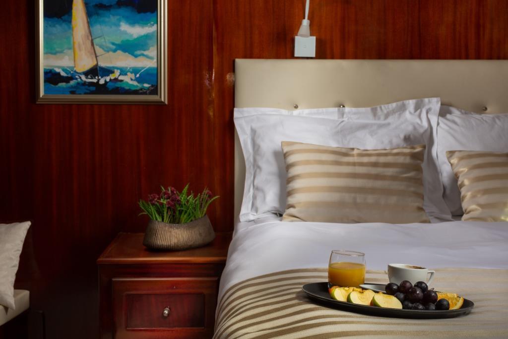 yacht master cabin with mahogany paneling breakfast tray on bed