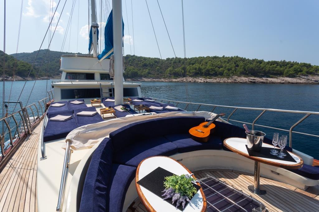 luxury gulet forward deck curved seating navy cushions champagne scenic coastline