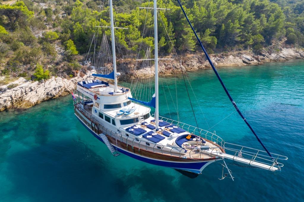Aerial view of traditional gulet yacht anchored in crystal clear Mediterranean waters