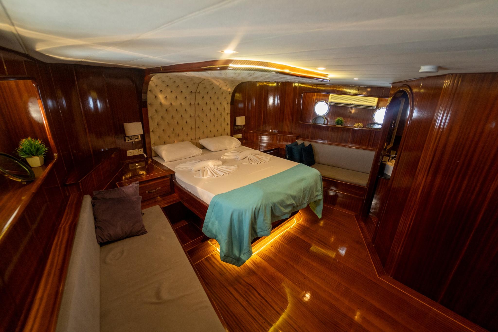 spacious yacht master cabin featuring king bed with tufted headboard and ambient lighting