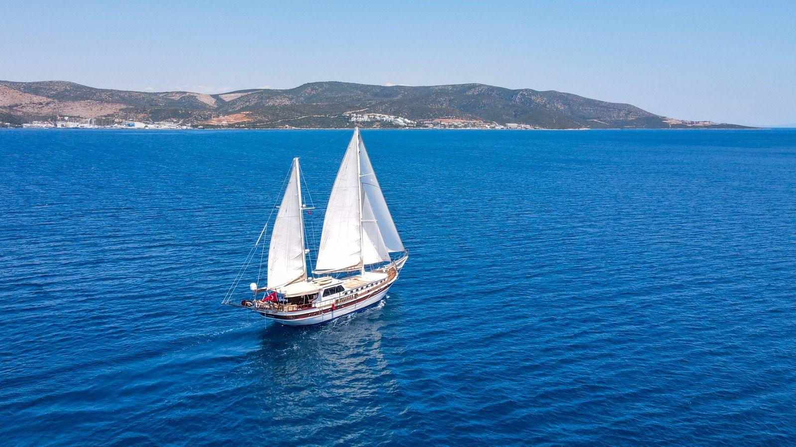 aerial view of traditional wooden gulet yacht under sail in deep blue Mediterranean waters