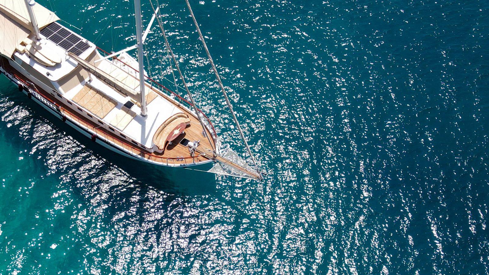 aerial view of traditional wooden gulet sailing yacht anchored in crystal clear turquoise Mediterranean waters