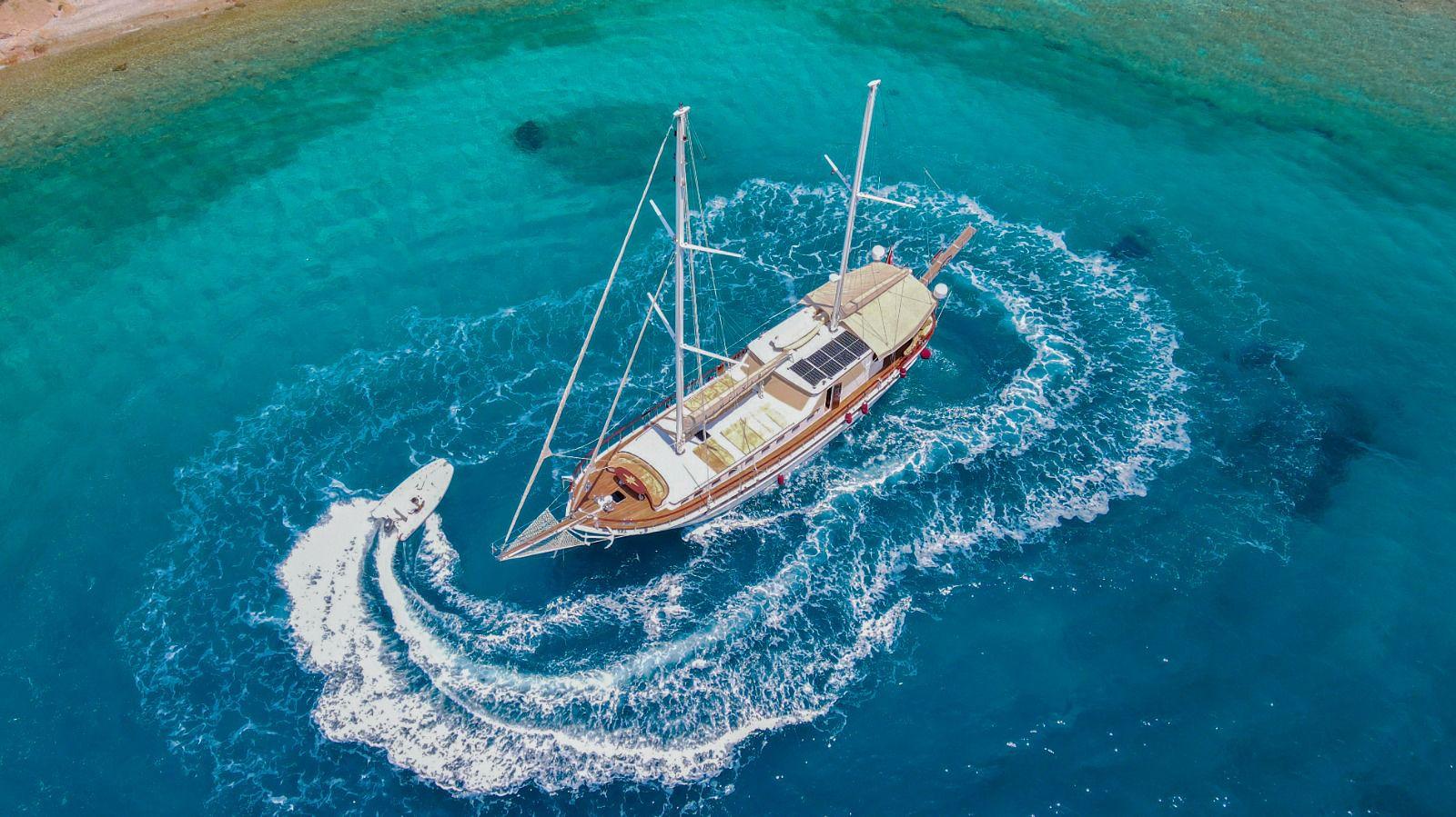 aerial view of traditional wooden gulet yacht anchored in crystal clear turquoise waters