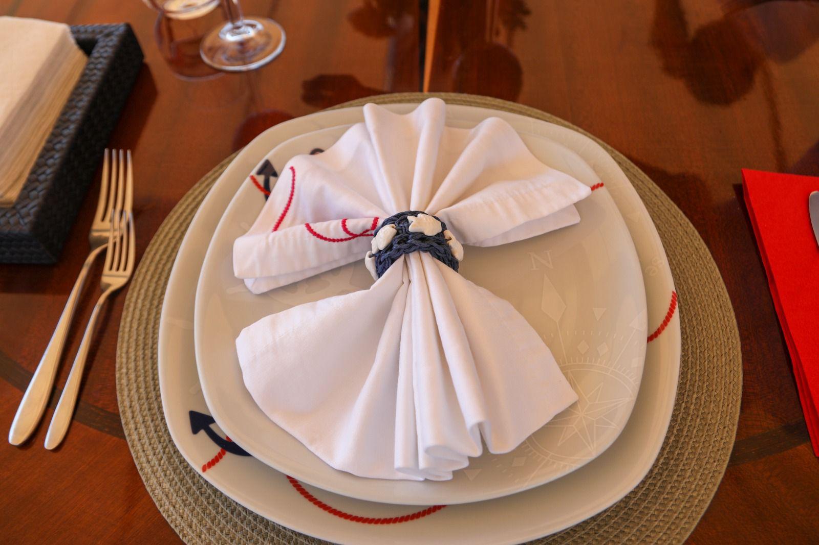 formal dining table setting with white napkin folded as flower with nautical rope napkin ring