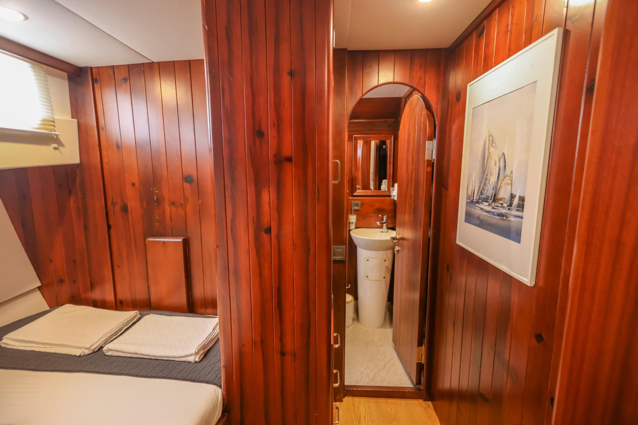yacht guest cabin featuring single bed with storage and connected en-suite bathroom