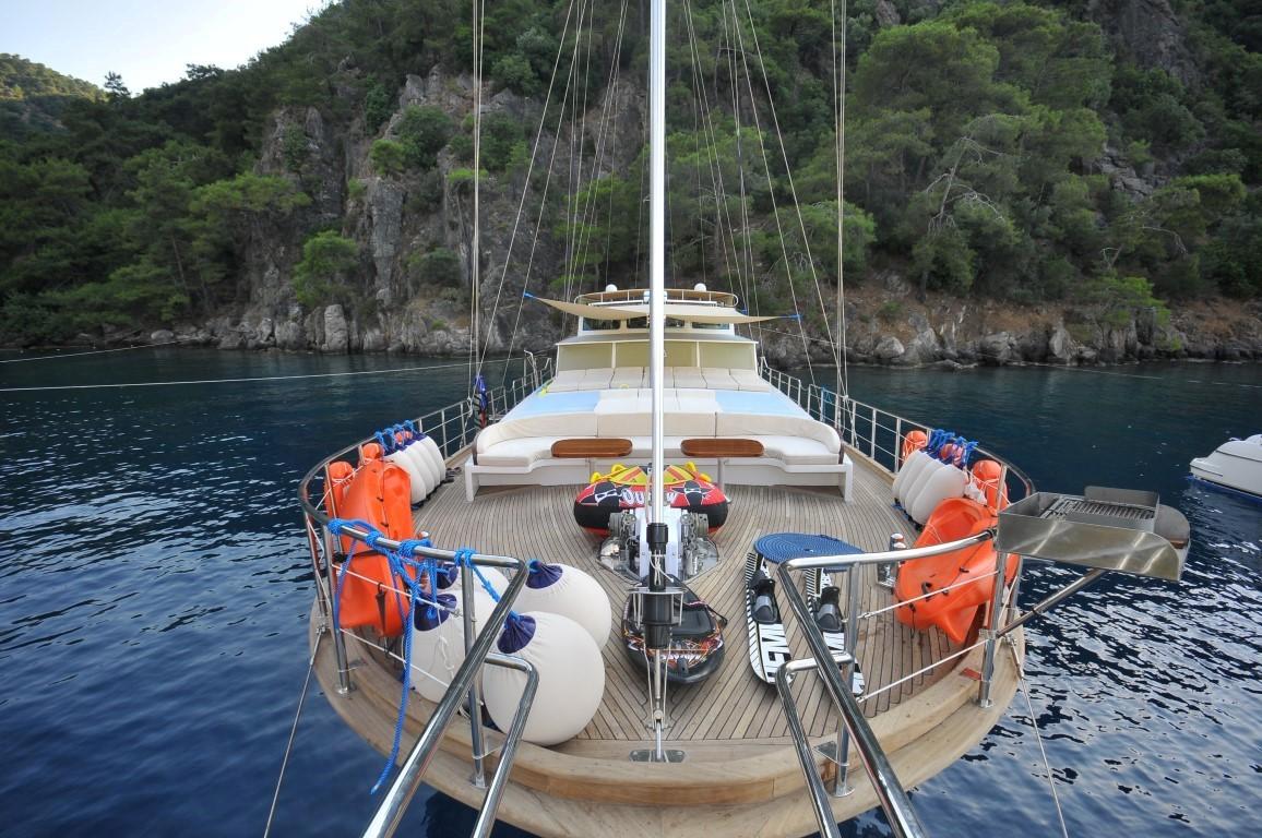 gulet stern deck with tender boat and orange life jackets stored around railings