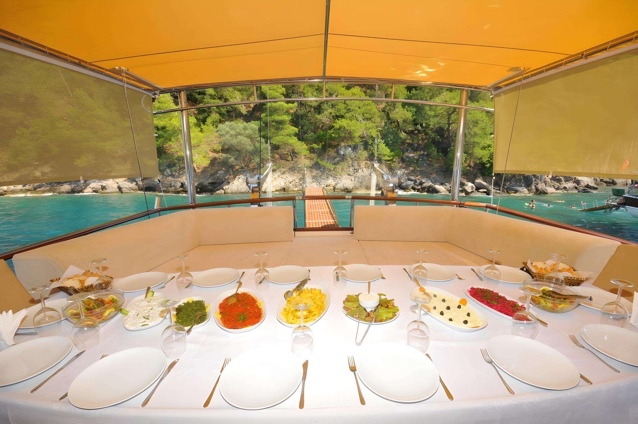yacht aft deck dining table with elaborate buffet spread and formal place settings
