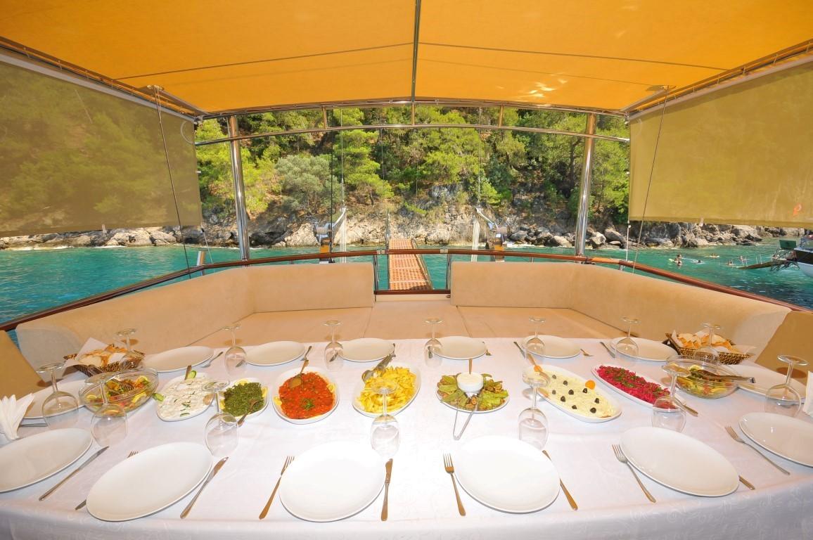 yacht aft deck dining table with elaborate buffet spread and formal place settings