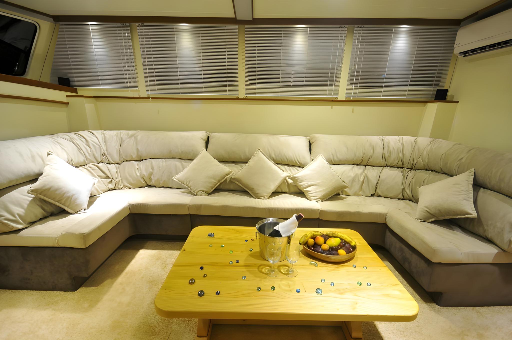 yacht salon interior with cream leather U-shaped sofa, yellow coffee table and horizontal blinds
