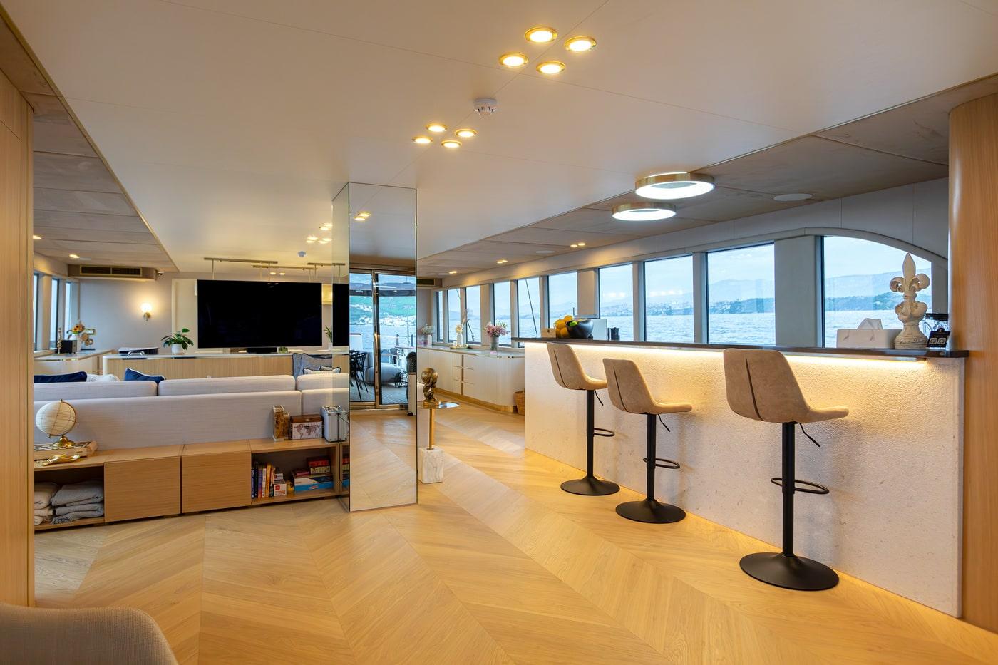 luxury yacht main salon interior with bar stools and ocean views