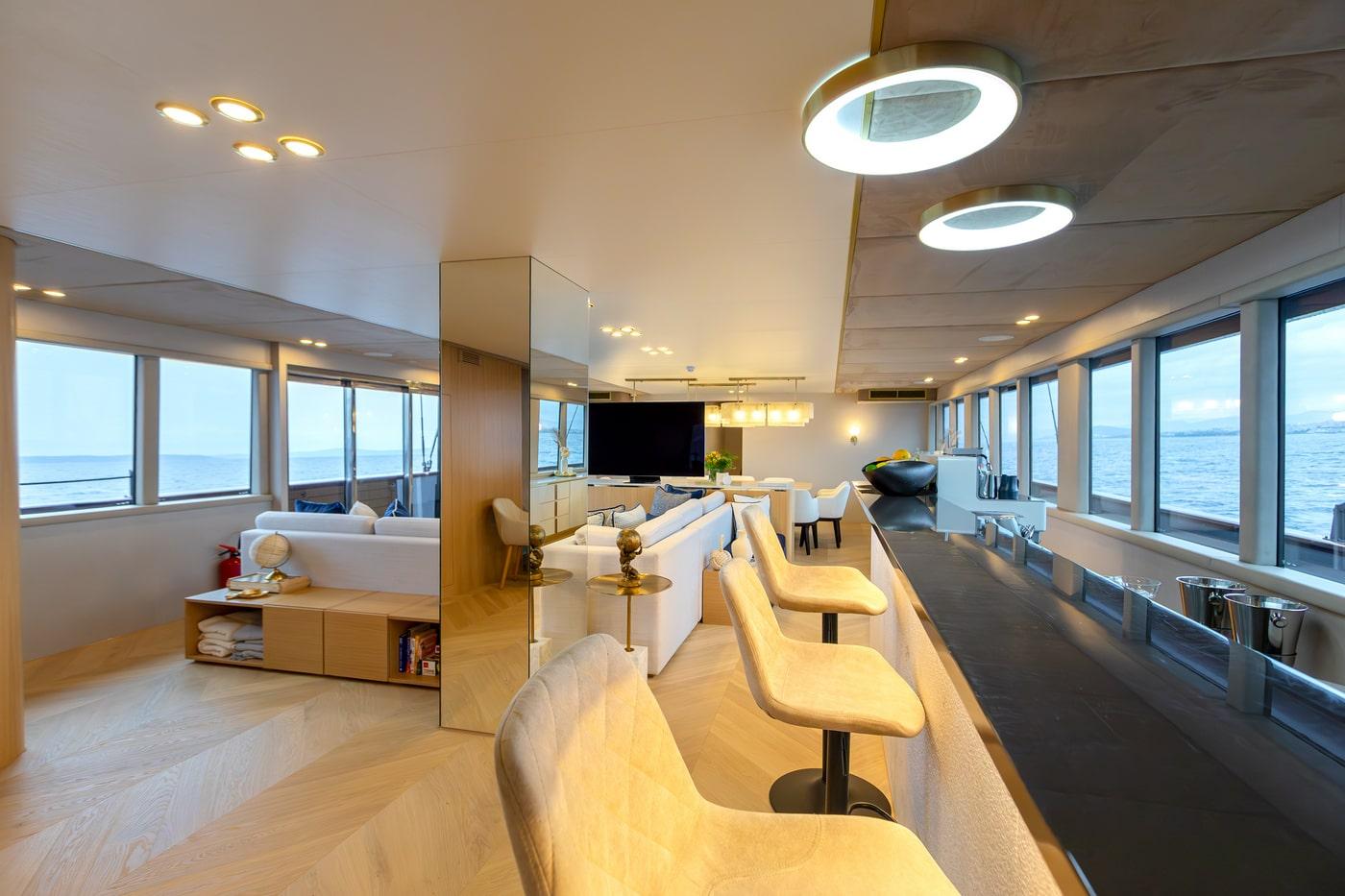 luxury yacht main salon interior with white sofa panoramic windows galley kitchen