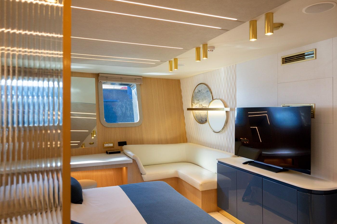 luxury yacht cabin interior with bed, built-in seating and modern amenities
