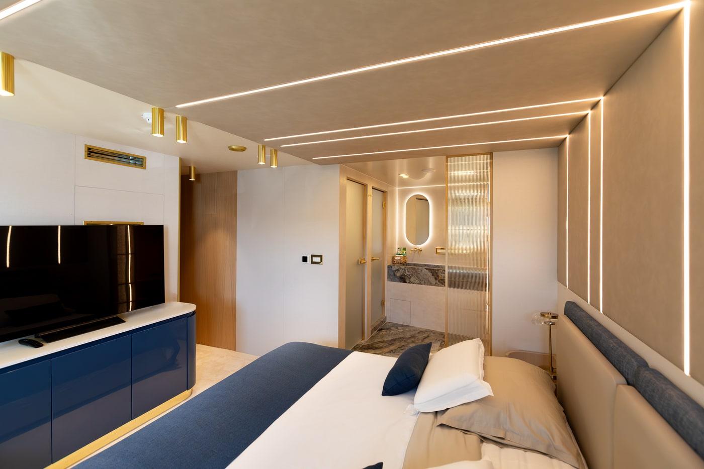 Modern yacht master bedroom with navy accents and marble en-suite bathroom