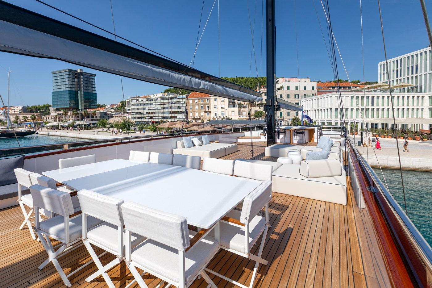 luxury yacht main deck with white dining table and teak flooring