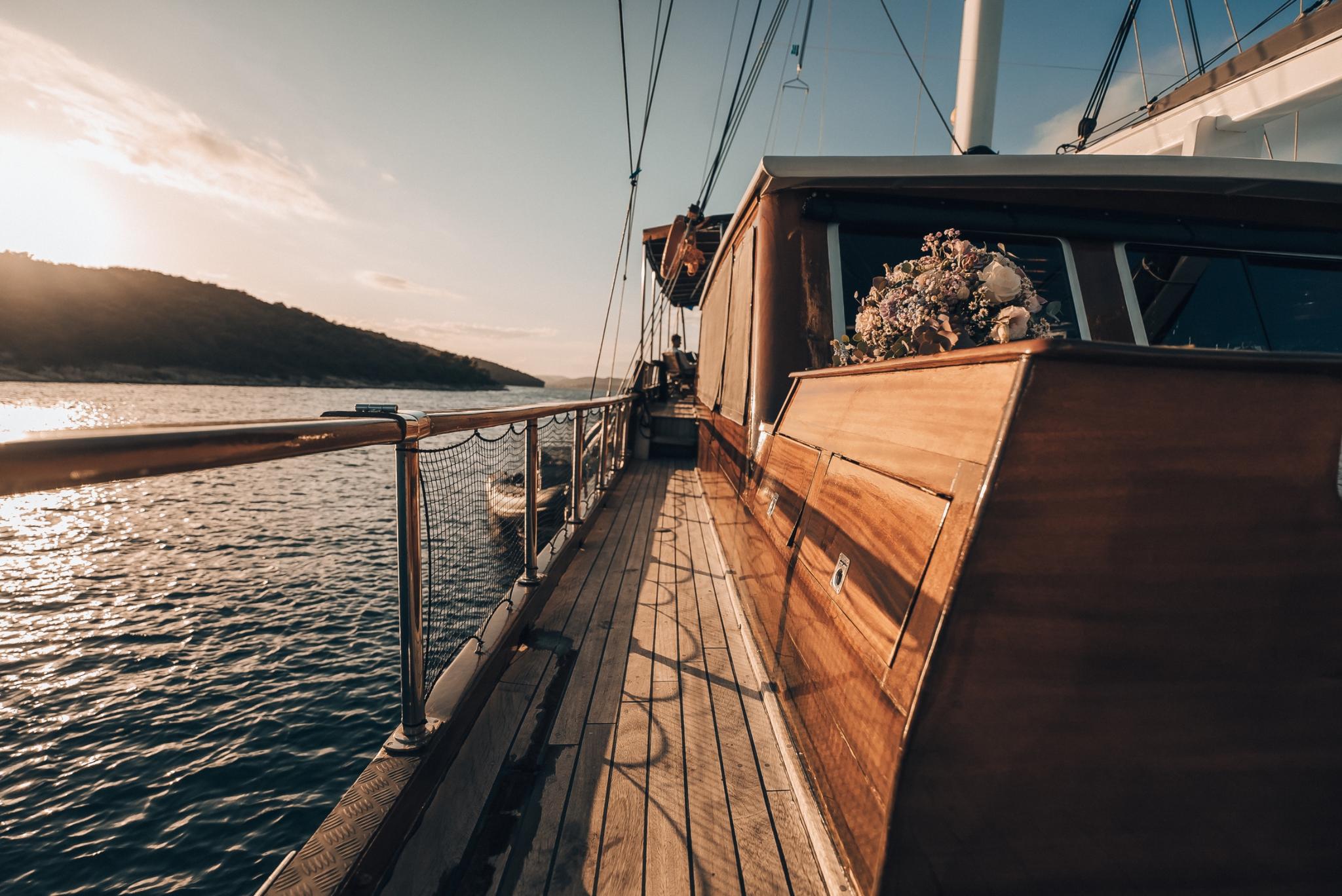 wooden side deck walkway with safety netting, rigging, and superstructure at golden hour