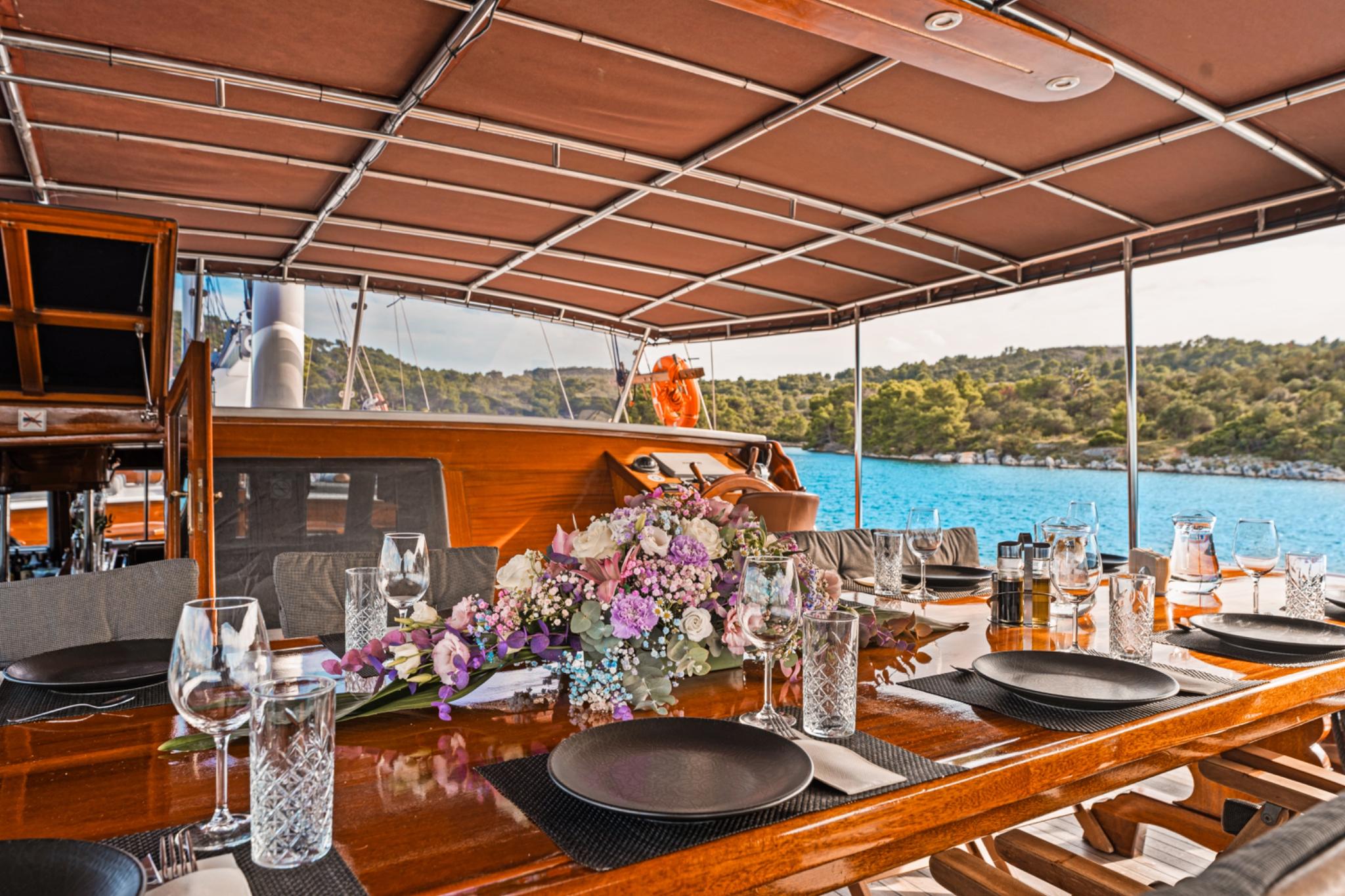 yacht aft deck dining area with formal table setting and floral centerpiece