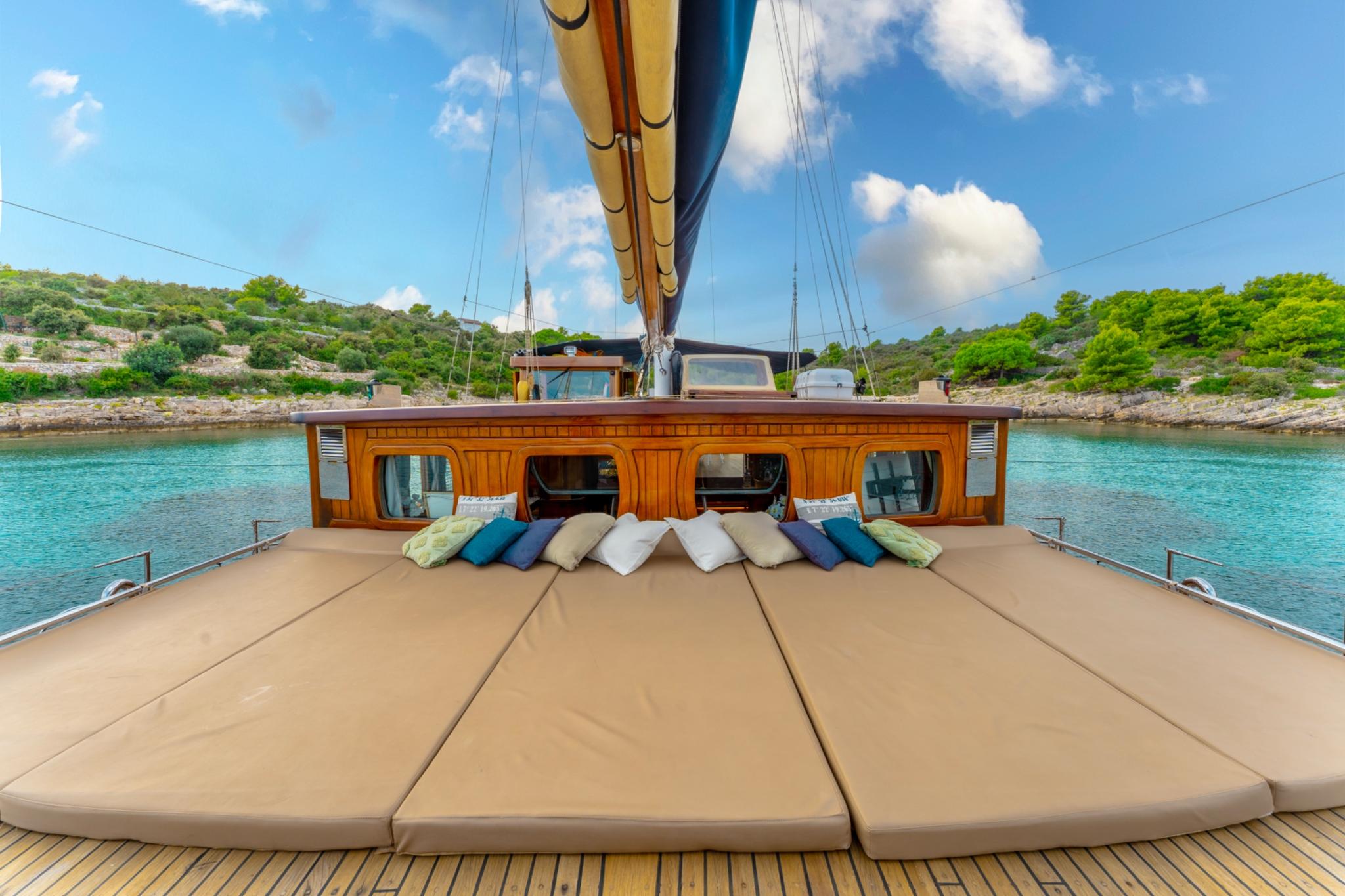 gulet forward deck sun pads with colorful cushions anchored in turquoise bay