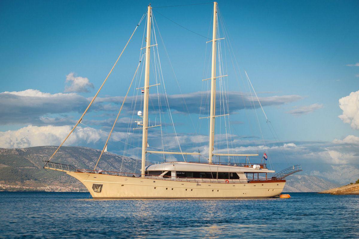 luxury white sailing yacht with two masts anchored in blue Mediterranean waters