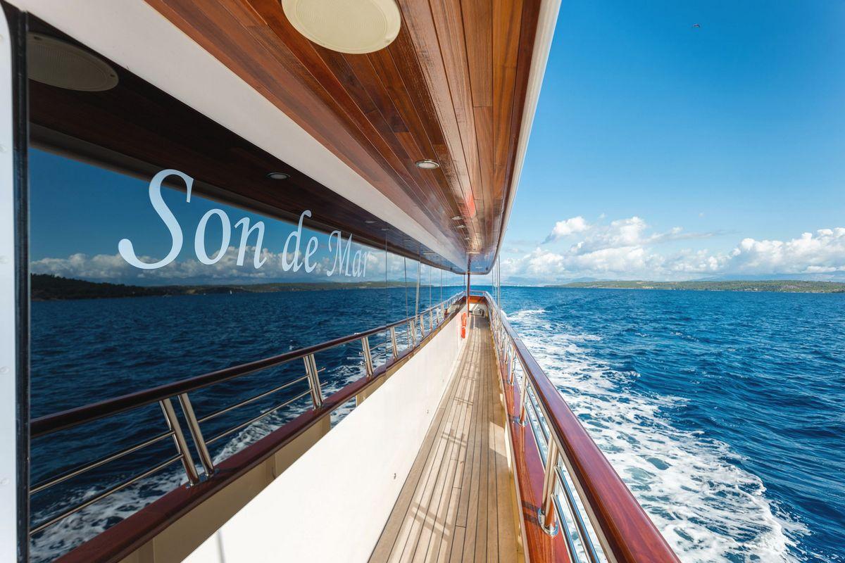 Teak side deck walkway of luxury yacht Son de Mar with wooden railings