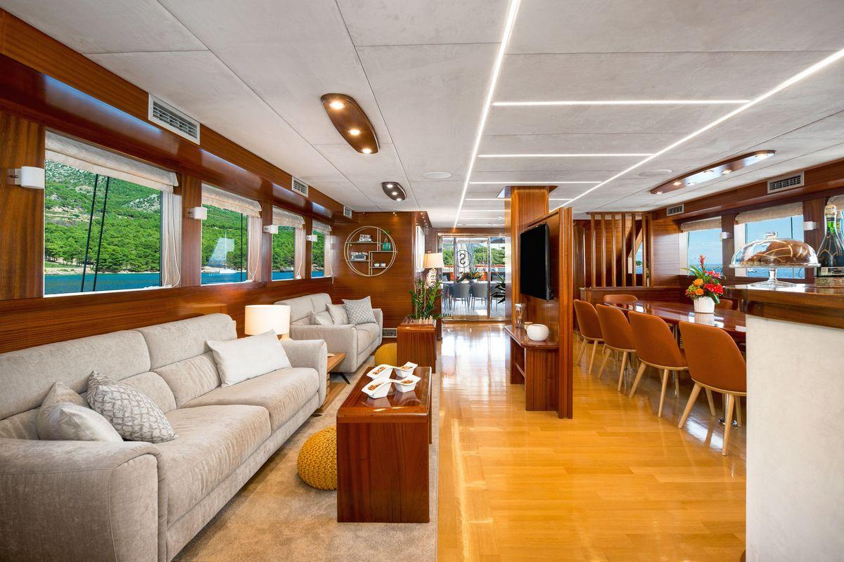 luxury yacht main salon with teak interior dining area and lounge seating