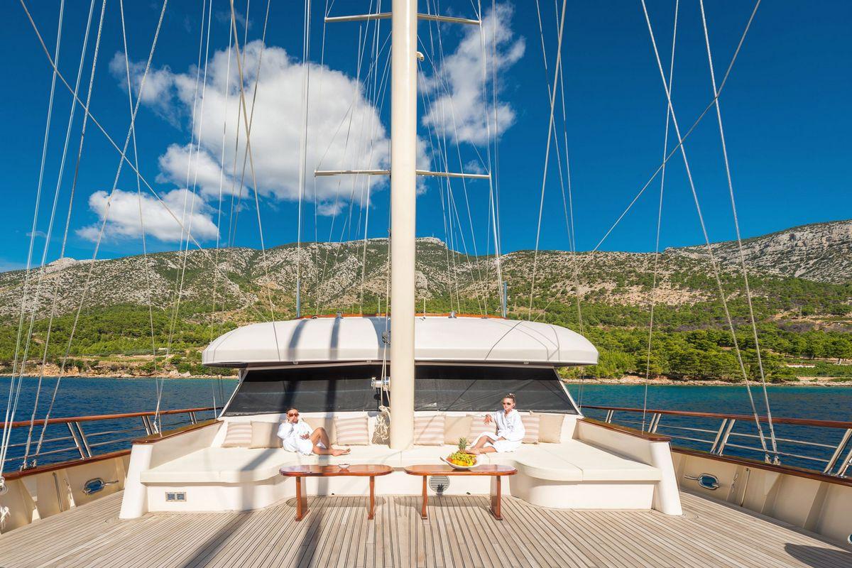 luxury gulet main deck with guests relaxing in Mediterranean bay