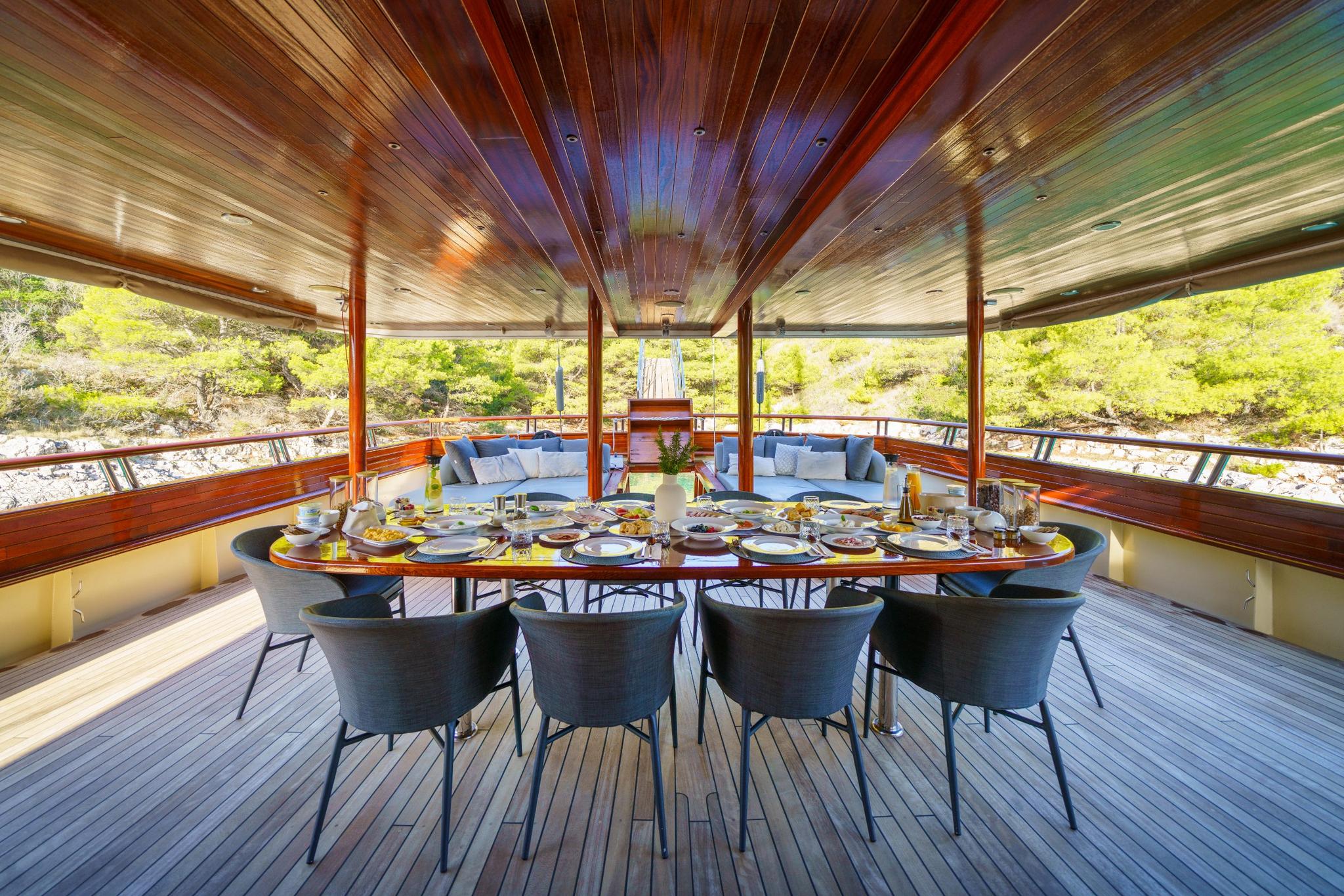 yacht aft deck dining area with circular table set with plates and food