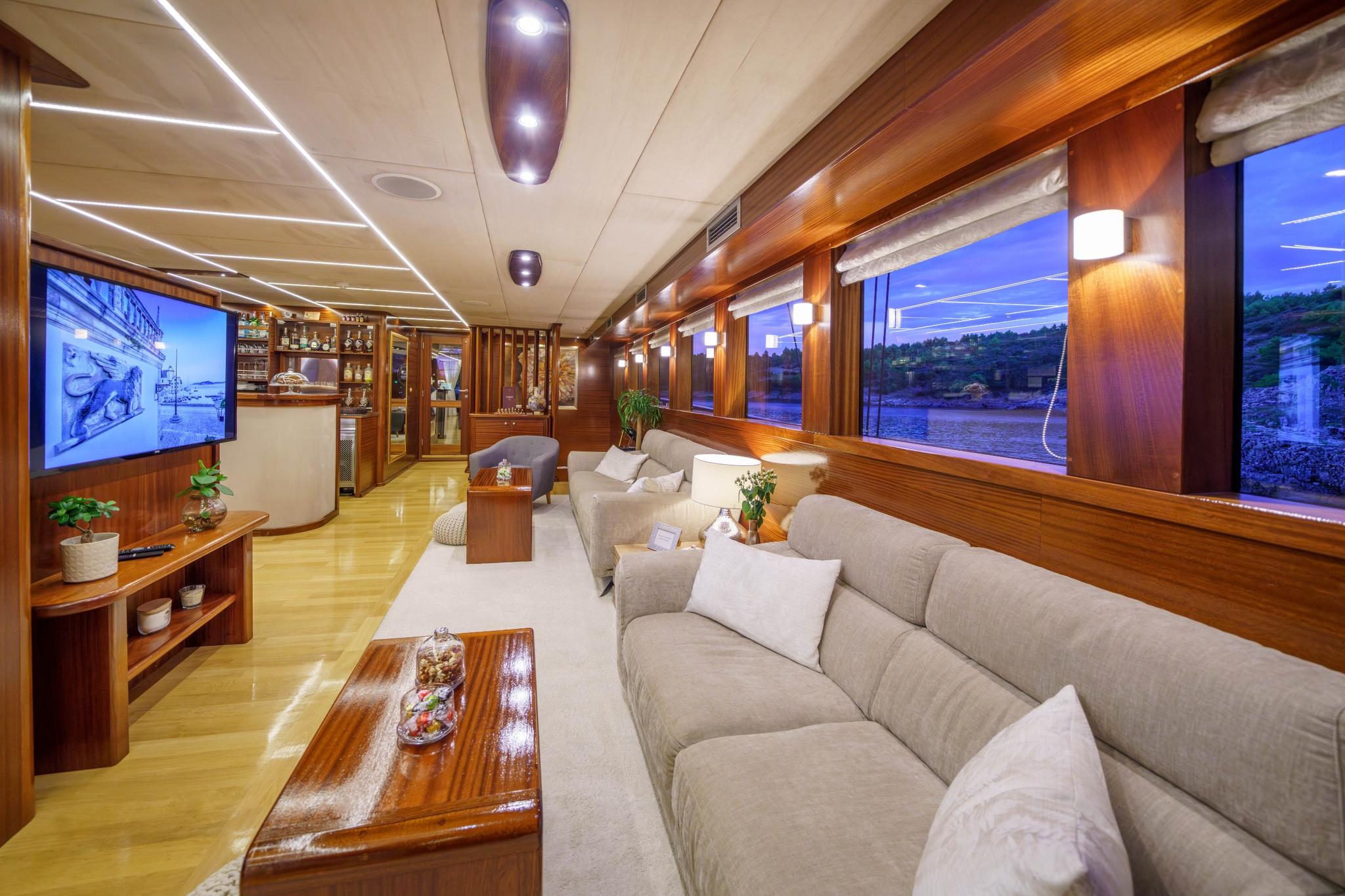 luxury yacht cinema room with large wall-mounted screen and comfortable gray seating area