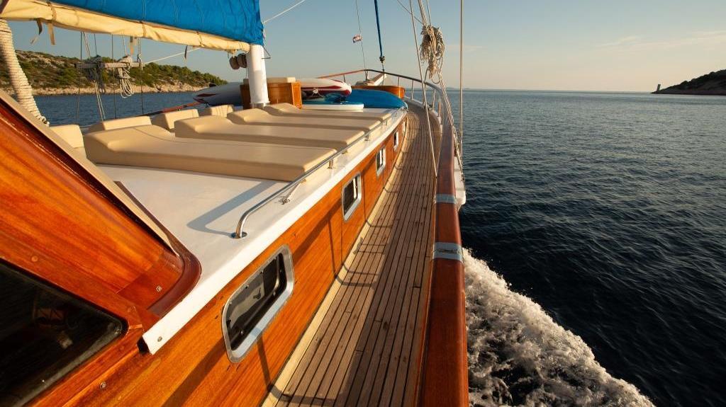 luxury yacht side deck with teak flooring and orange trim underway