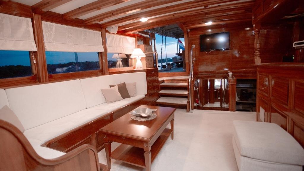 Luxury gulet salon with wooden beams white sofa and panoramic windows