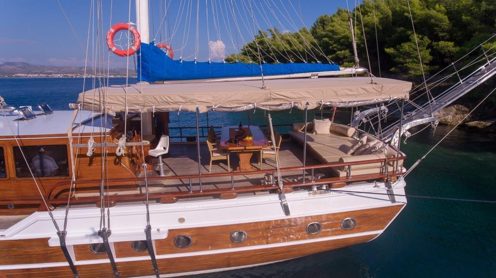 traditional wooden gulet yacht with awning moored in crystal clear turquoise waters