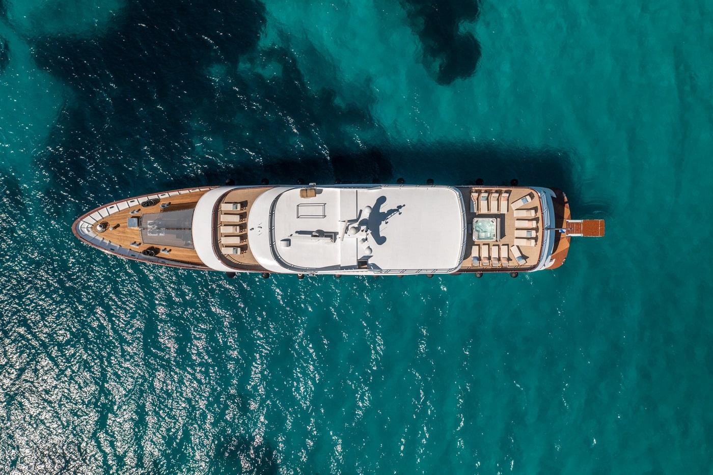 aerial drone shot of luxury yacht anchored in crystal clear turquoise water