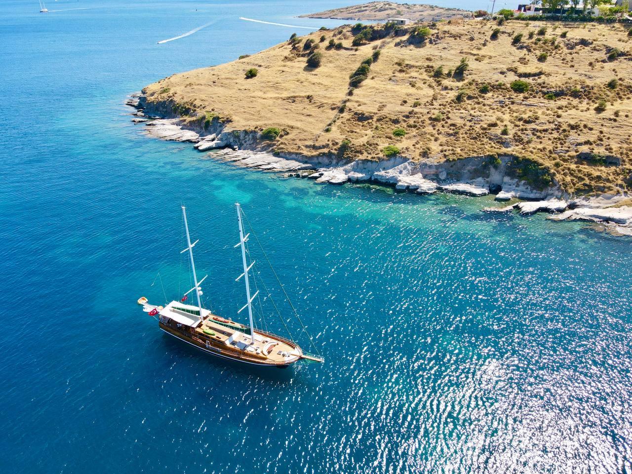 aerial view of traditional gulet yacht anchored in crystal clear turquoise Mediterranean bay