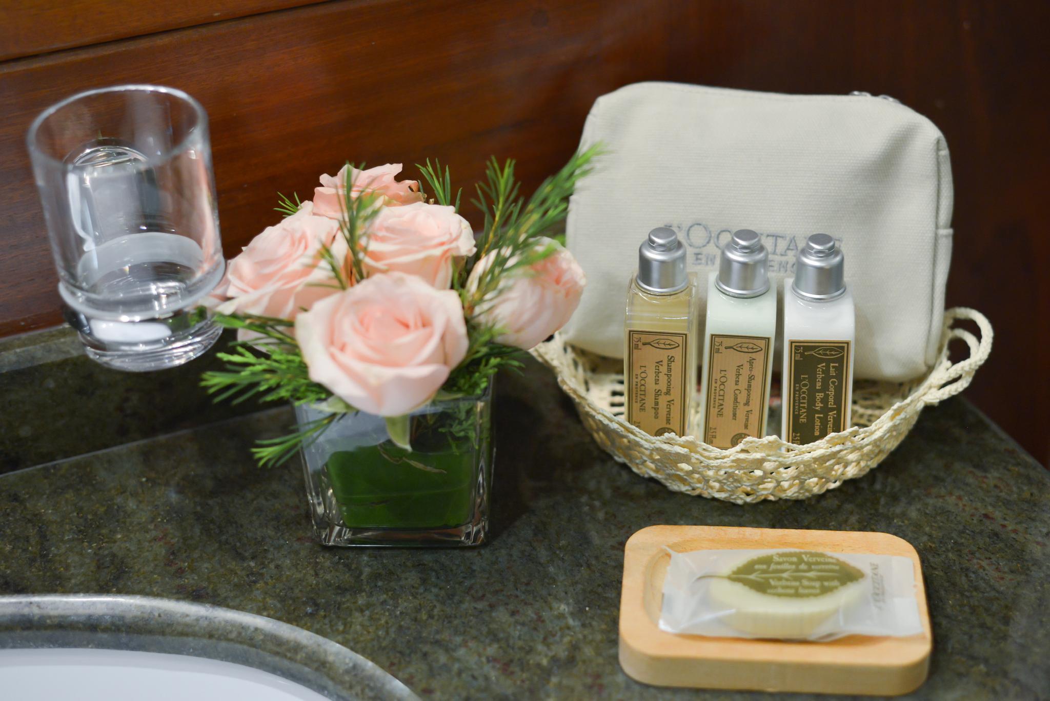 yacht bathroom counter with luxury toiletries, pink roses, and guest amenities