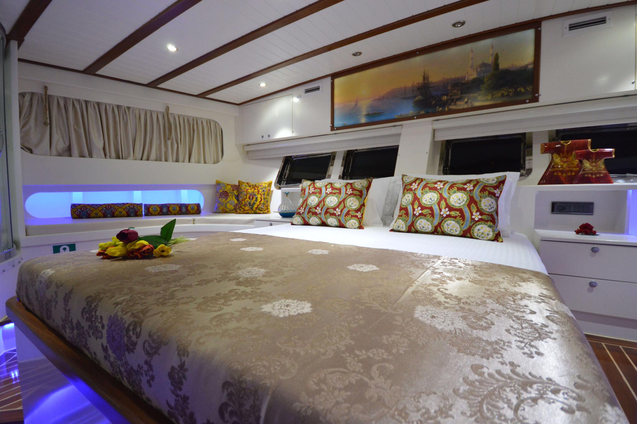 luxury yacht master cabin featuring king bed with decorative pillows and panoramic windows