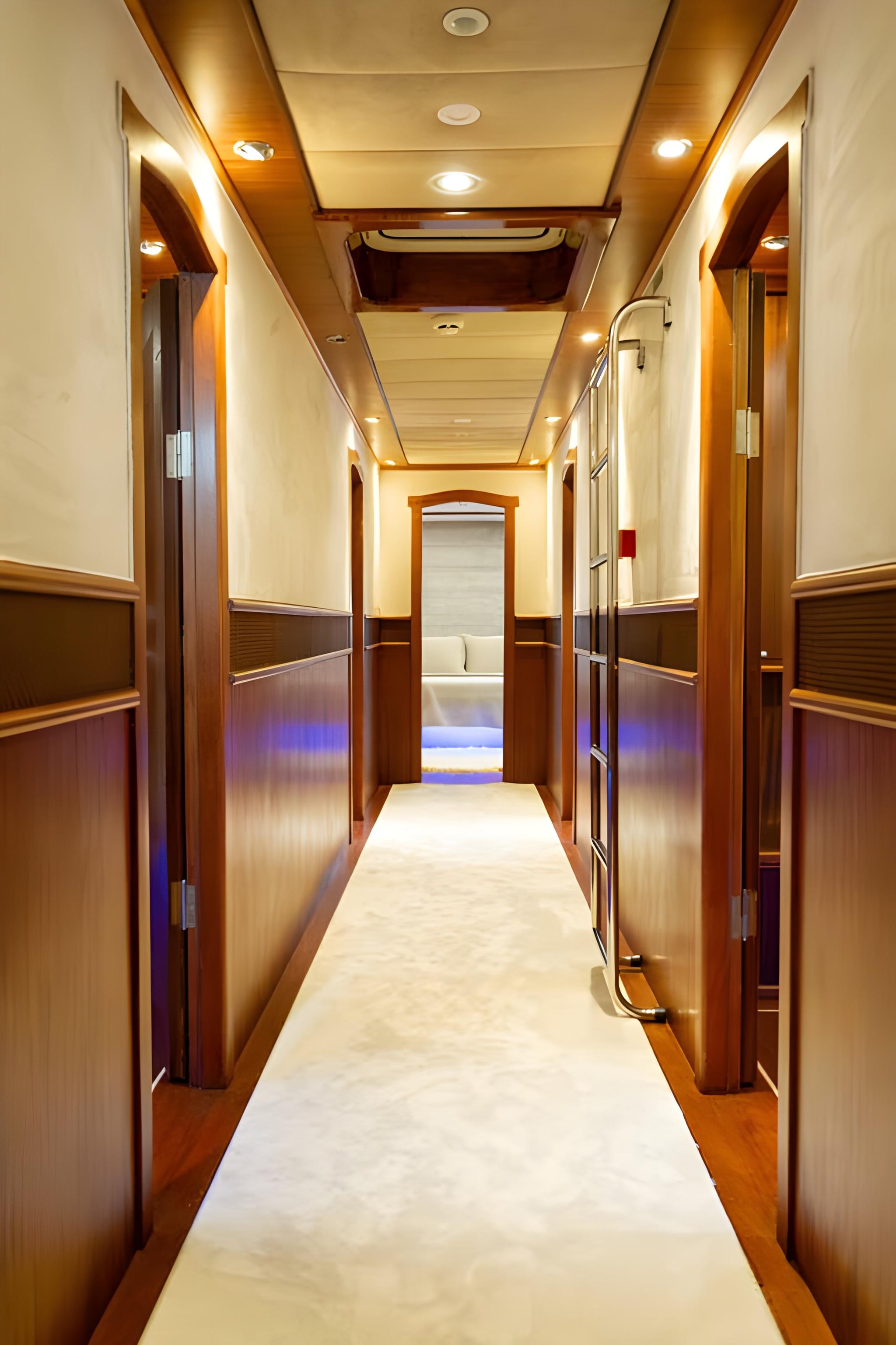 yacht interior corridor with wooden paneled walls and multiple cabin doors