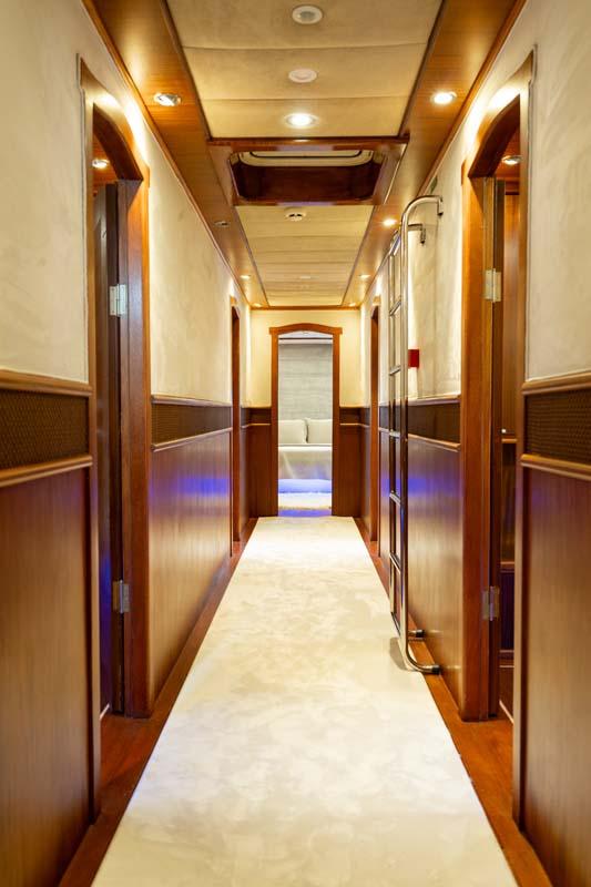 yacht interior corridor with wooden paneled walls and multiple cabin doors