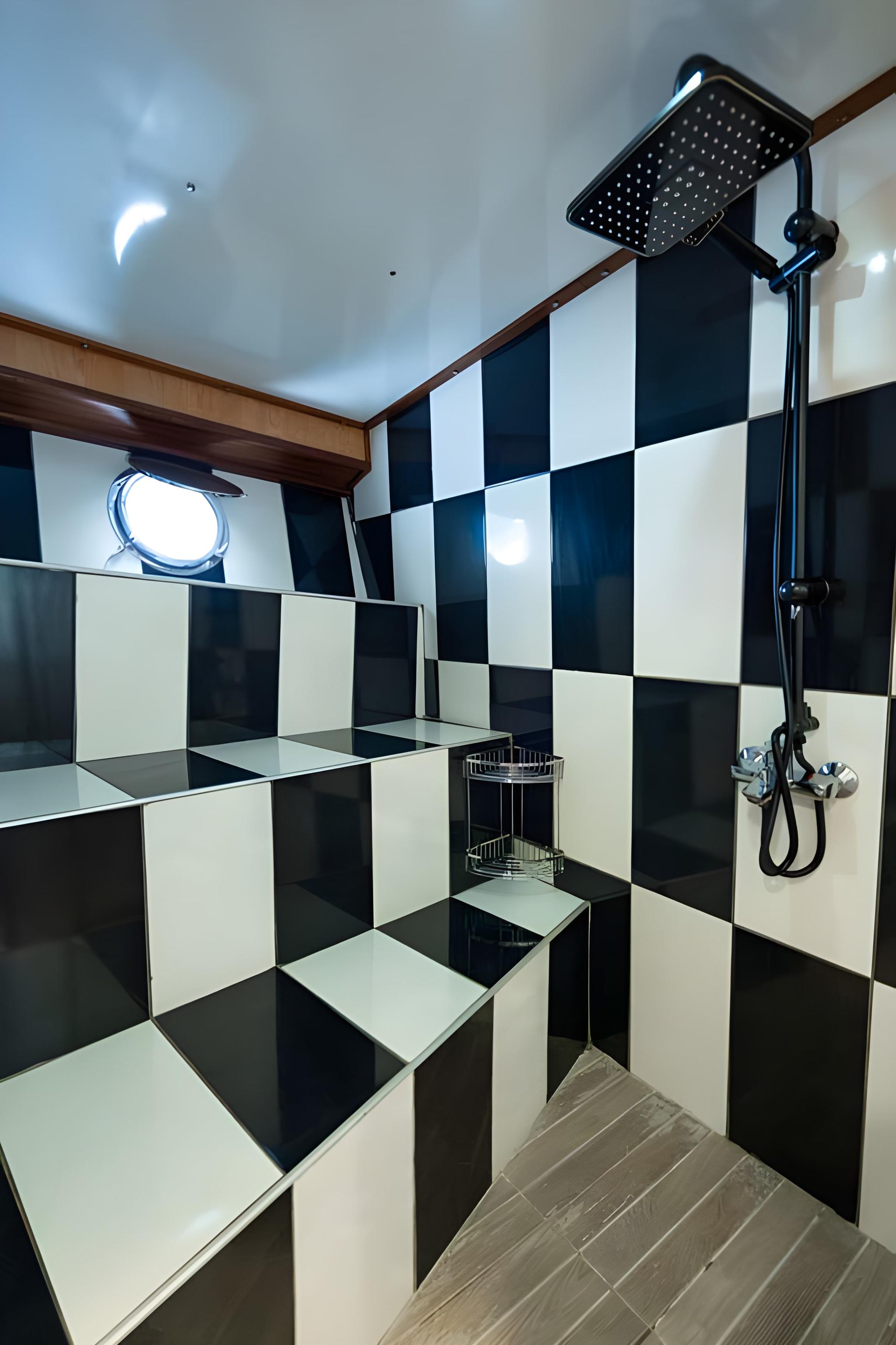 yacht bathroom featuring black and white checkered tile walls and rainfall shower head