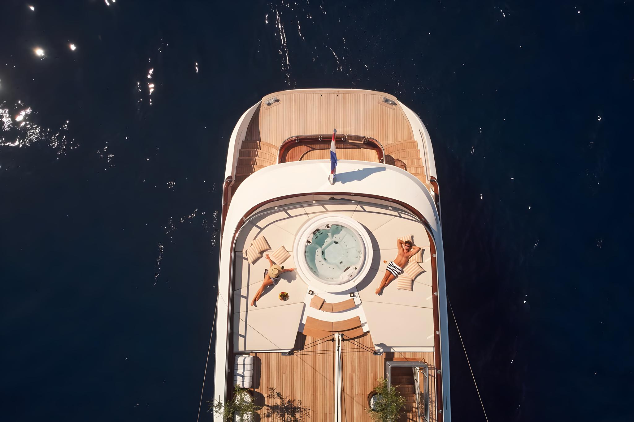 Aerial view luxury motor yacht circular jacuzzi teak decking sunbathers