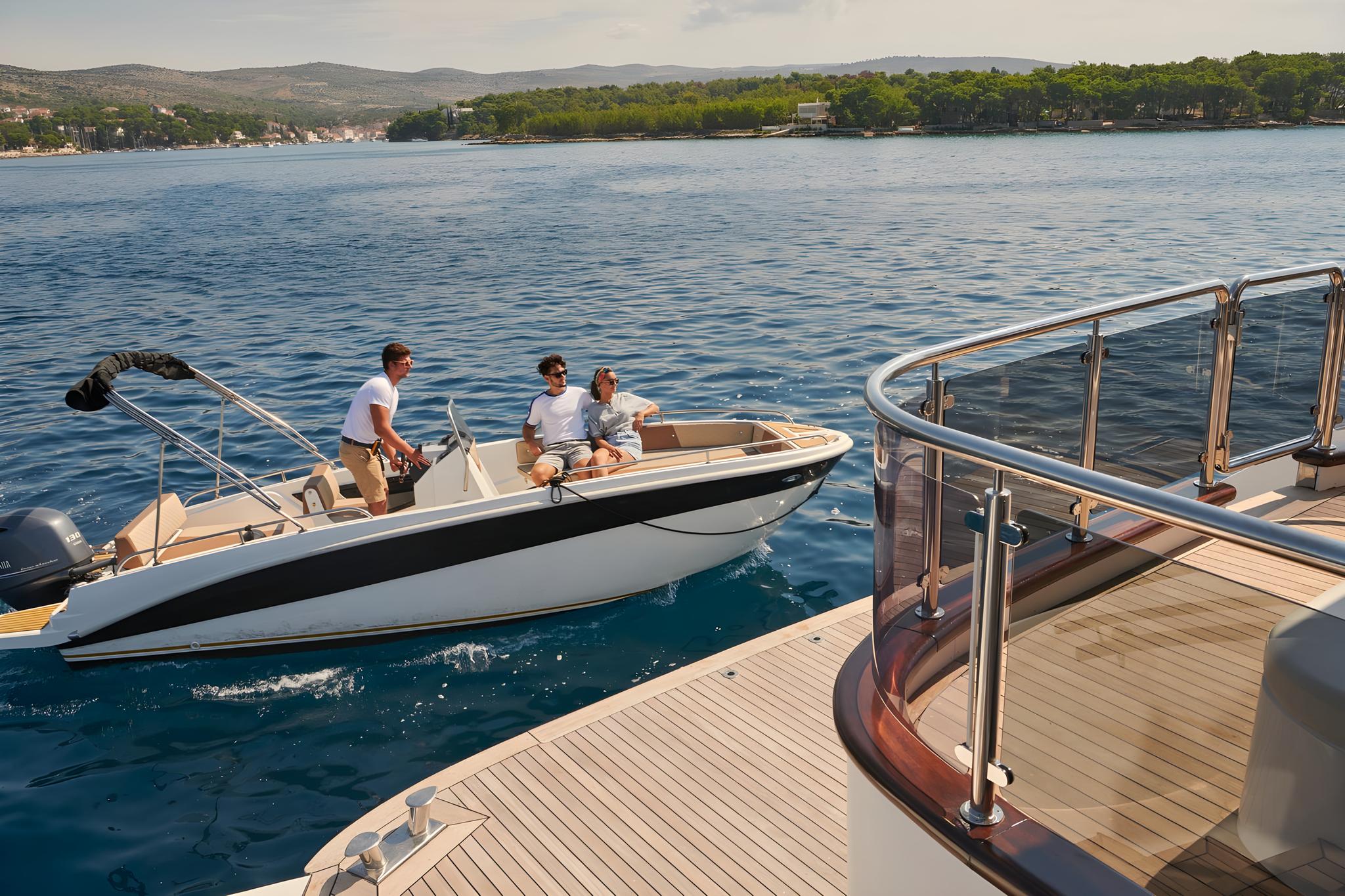 Luxury yacht tender boat with three guests alongside main yacht deck