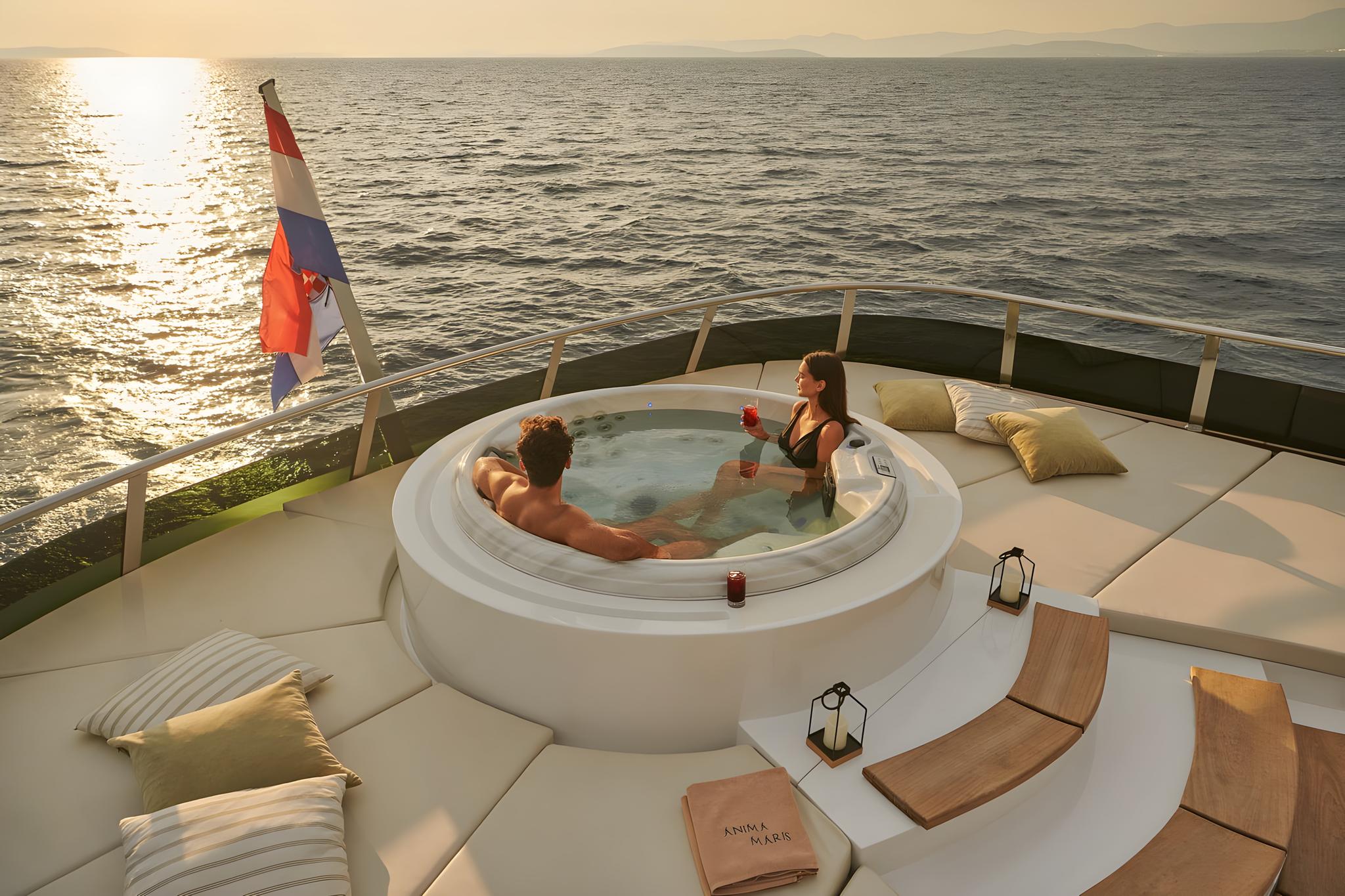 luxury yacht jacuzzi with guests relaxing at golden hour sunset