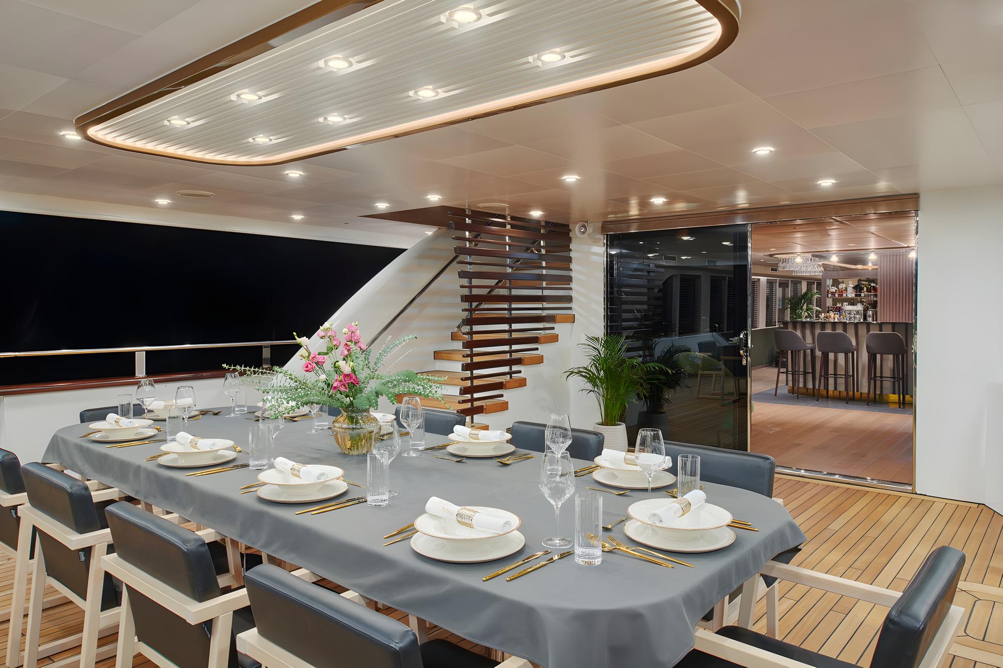 Elegant yacht dining salon with formal table setting for ten guests
