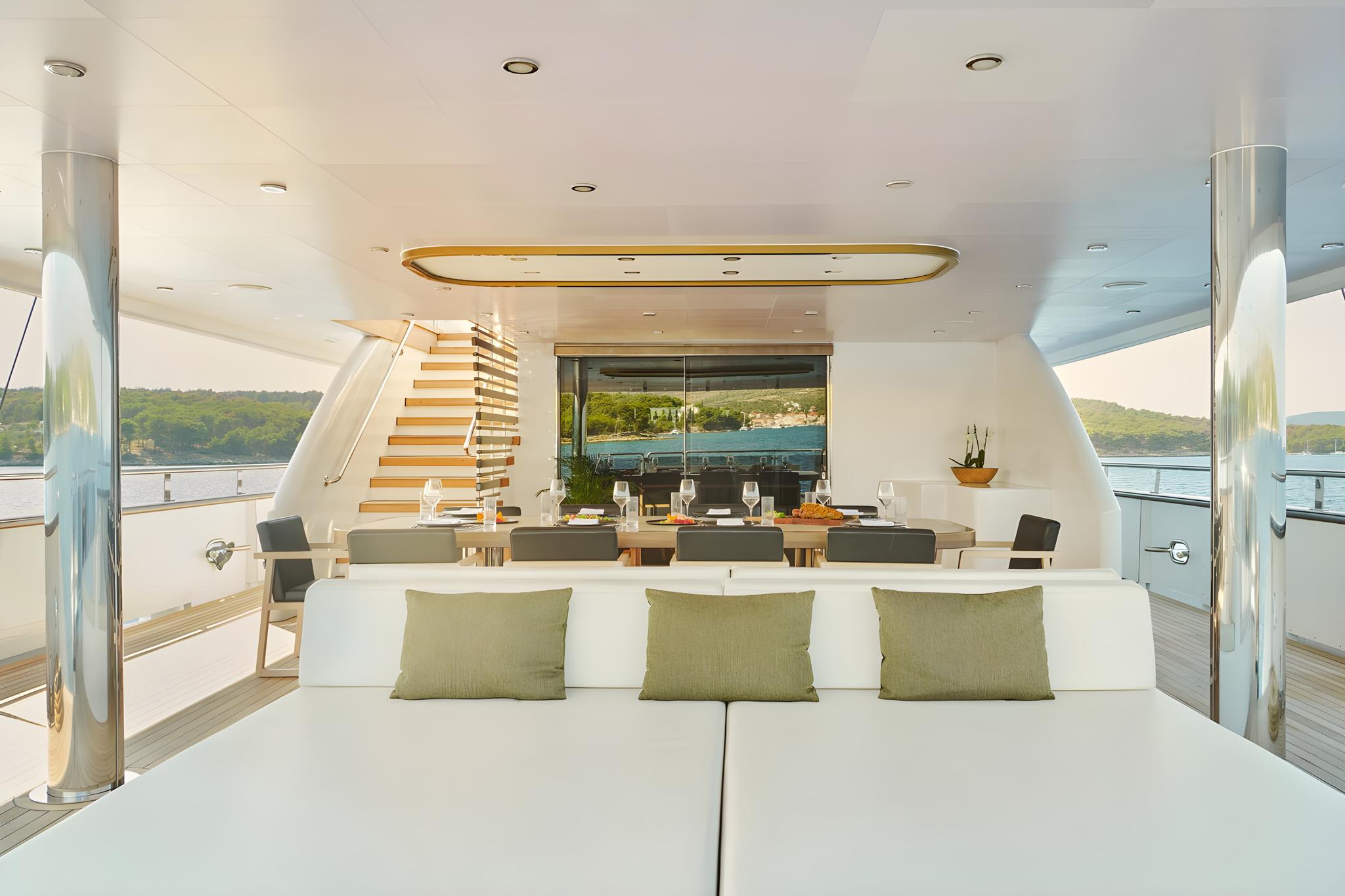 luxury yacht main salon with white seating dining table modern staircase