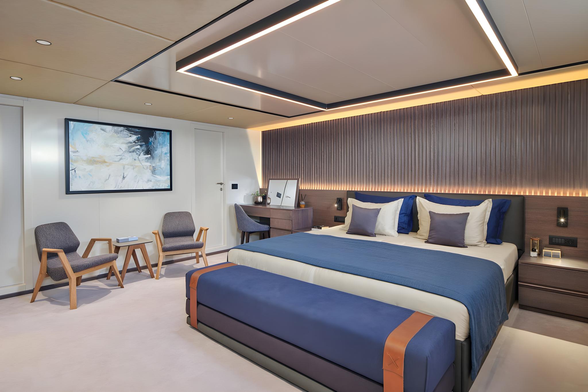 Elegant yacht master cabin featuring navy blue bedding and wood accent wall
