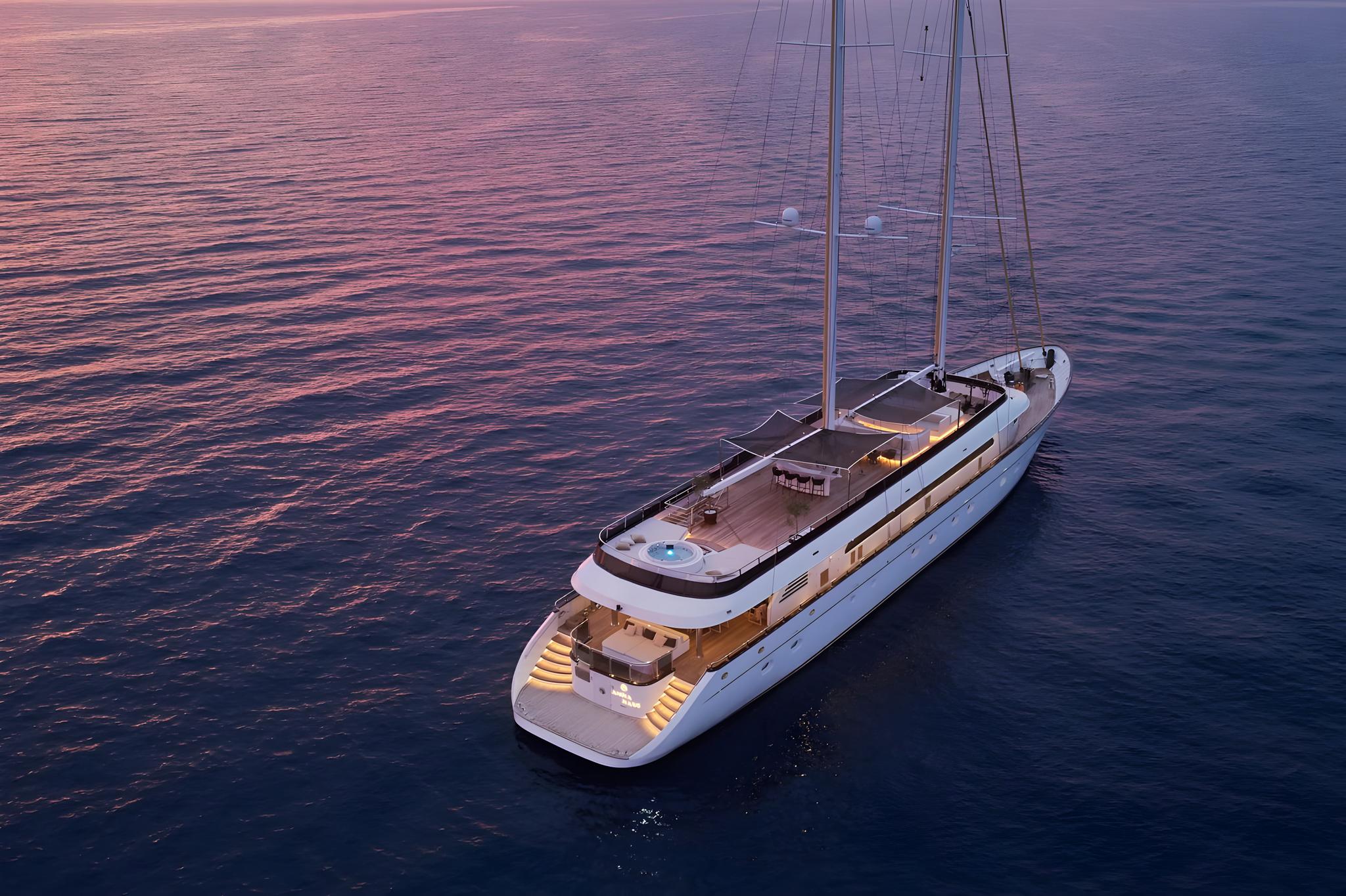 Aerial view of white luxury sailing yacht on calm water at sunset