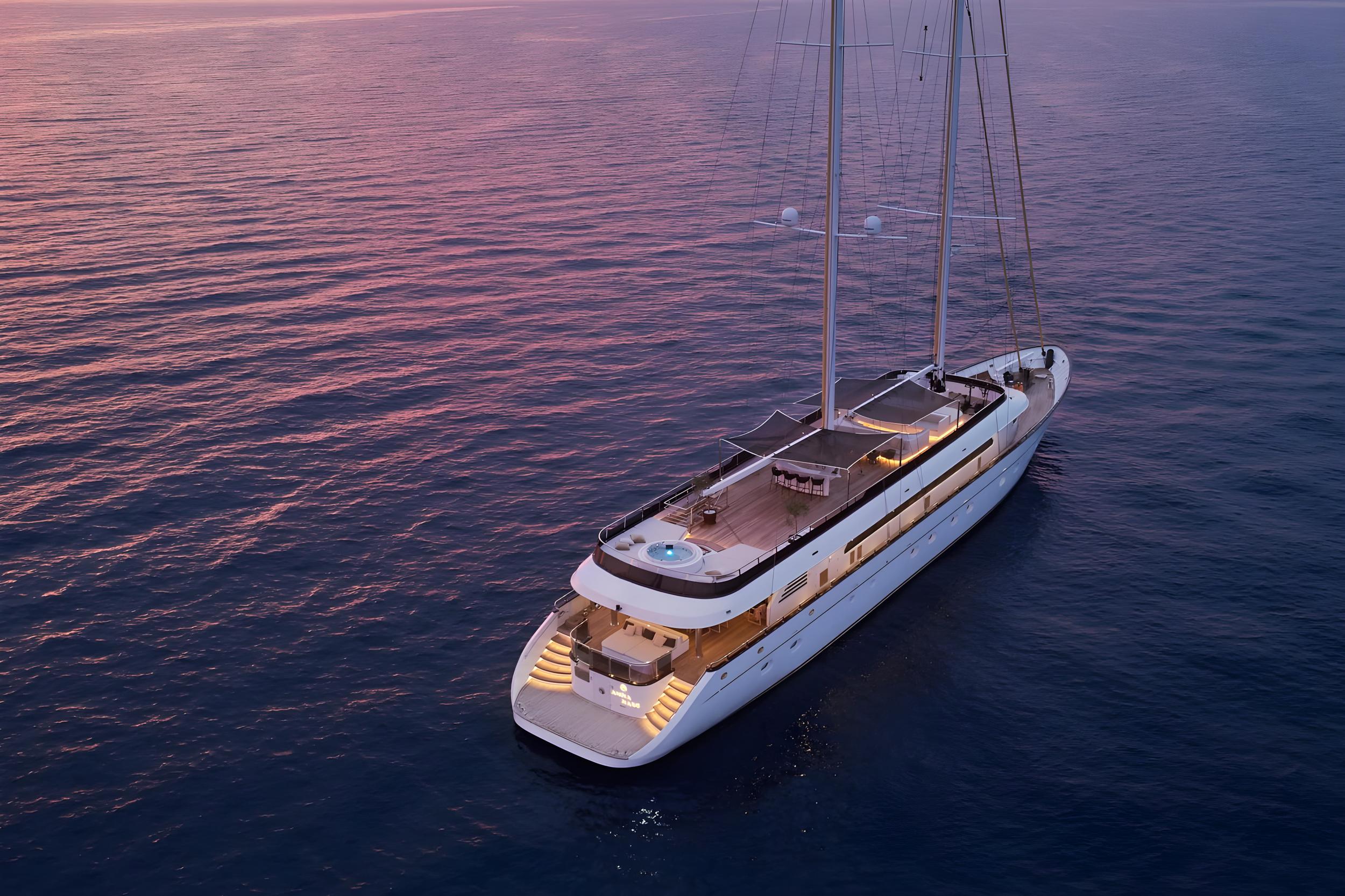 Aerial view of white luxury sailing yacht on calm water at sunset
