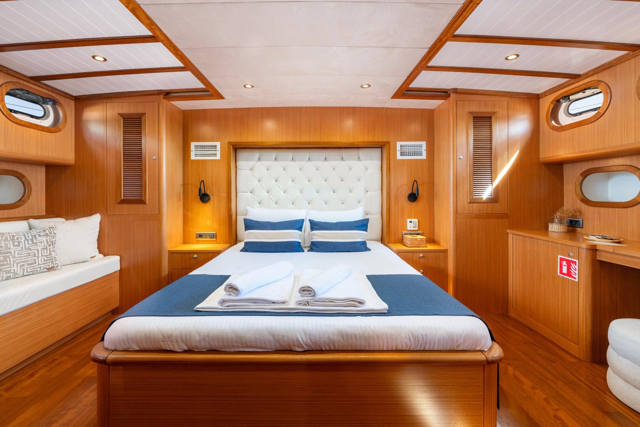 yacht master cabin with white tufted headboard king bed and blue runner