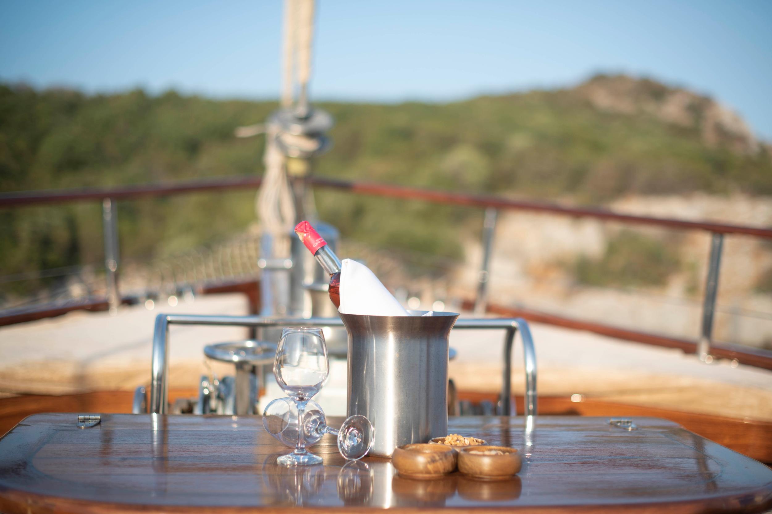 champagne bottle in ice bucket with wine glasses on yacht dining table