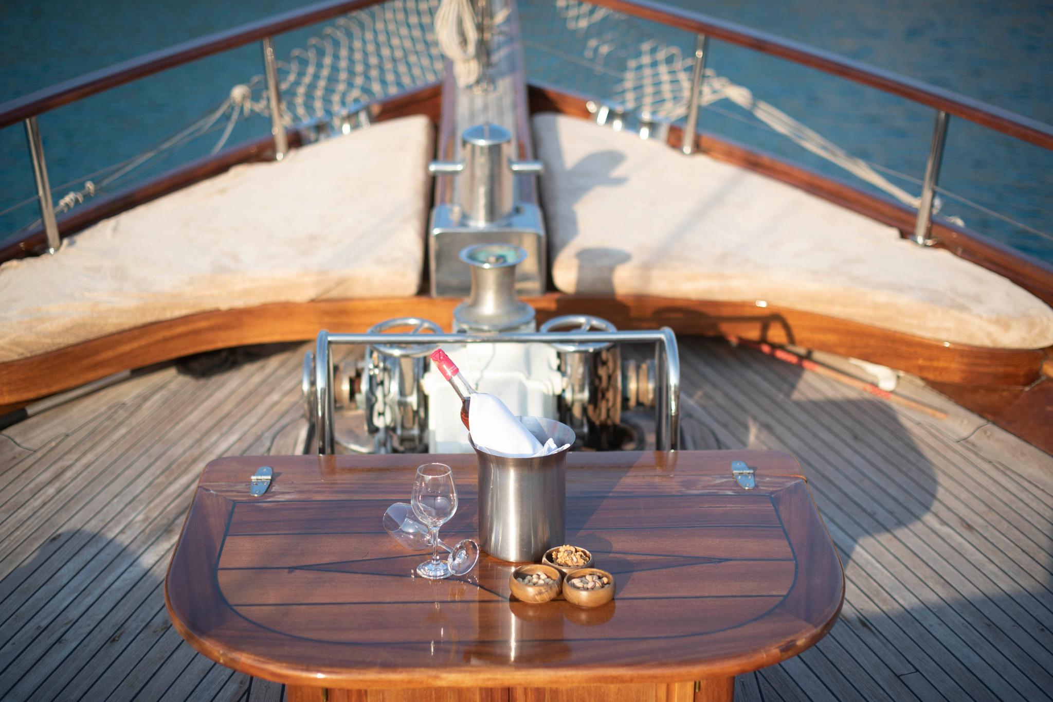 champagne bottle in ice bucket with wine glasses and appetizer bowls on wooden table