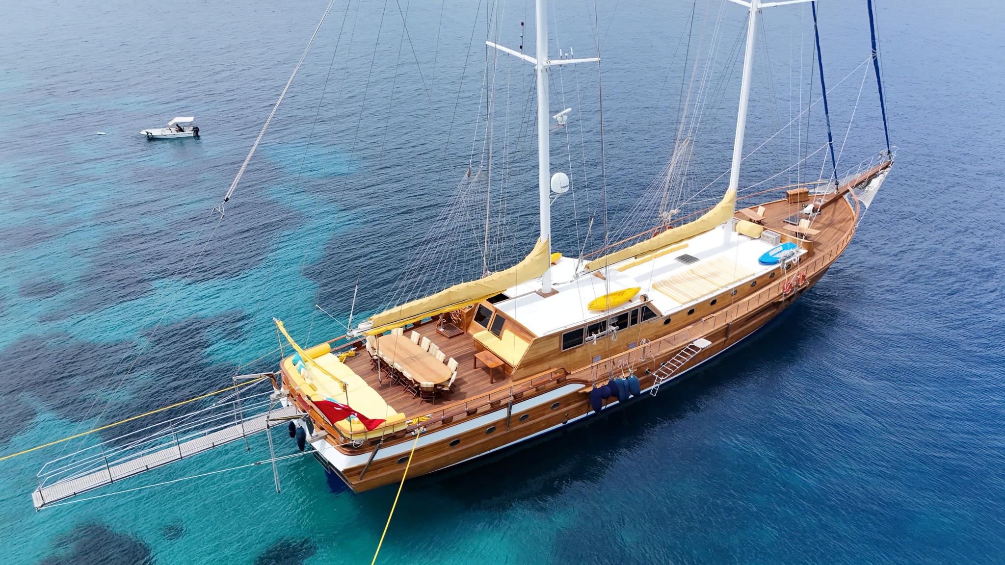 aerial drone shot of wooden gulet yacht anchored in crystal clear turquoise waters